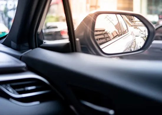 View through a car side mirror while driving